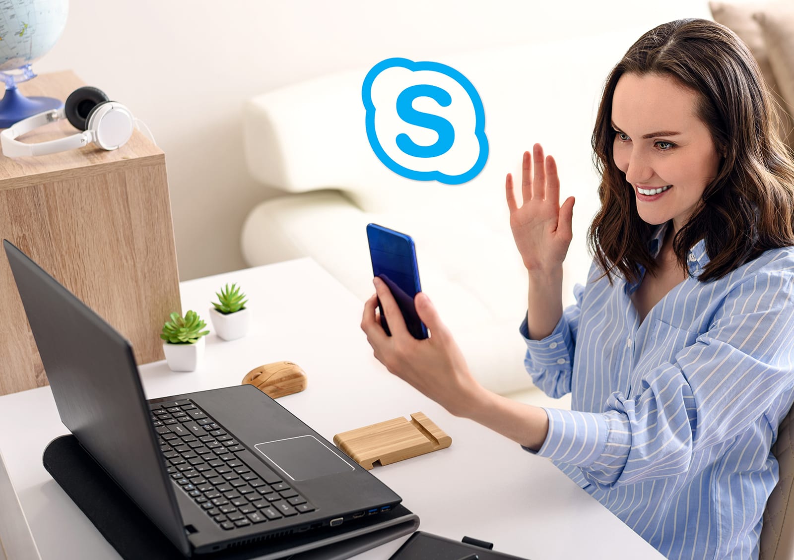 One Woman In Blue Shirt Sitting Talking On Smartphone And Working On Remote Access In Apartment
