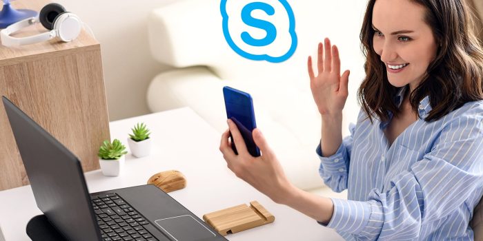 One Woman In Blue Shirt Sitting Talking On Smartphone And Working On Remote Access In Apartment